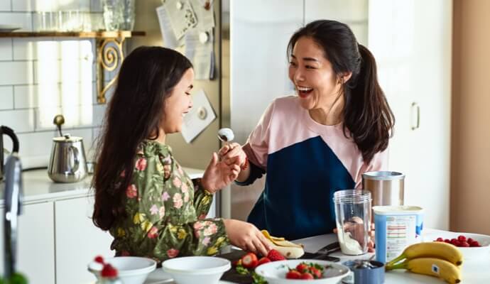 Donna e bambino che ridono mentre cucinano insieme