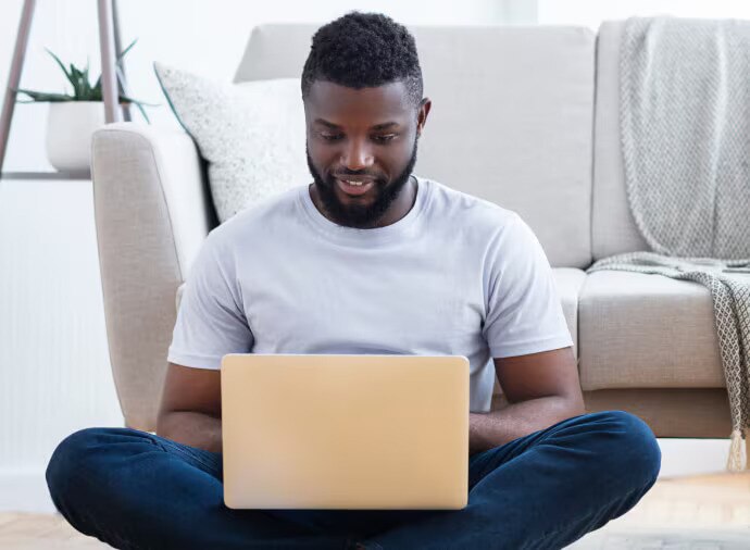Uomo seduto che usa il computer portatile