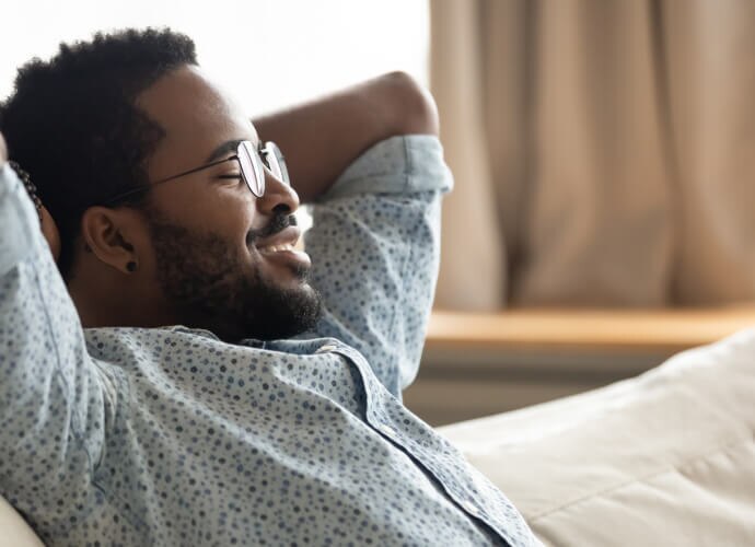 Uomo sorridente seduto su un divano
